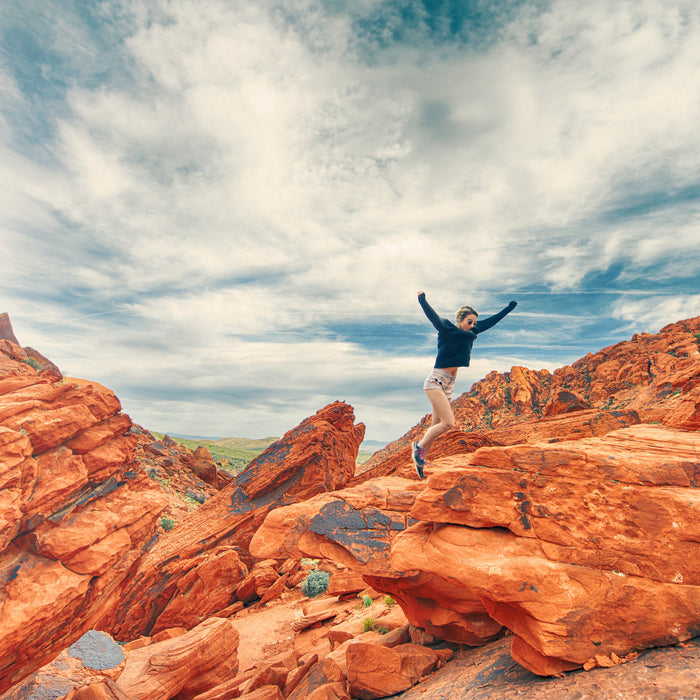 Happy man jumping in a rocky mountain